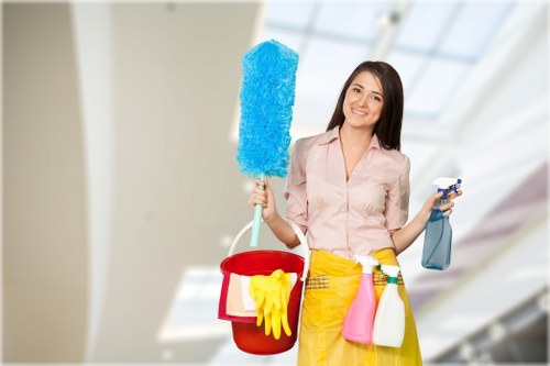 Cleaner wearing PPE while treating a carpeted area with professional equipment